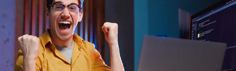 man with a computer in a winning pose